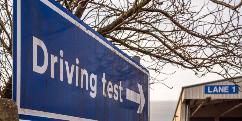 A blue sign with the words: driving test