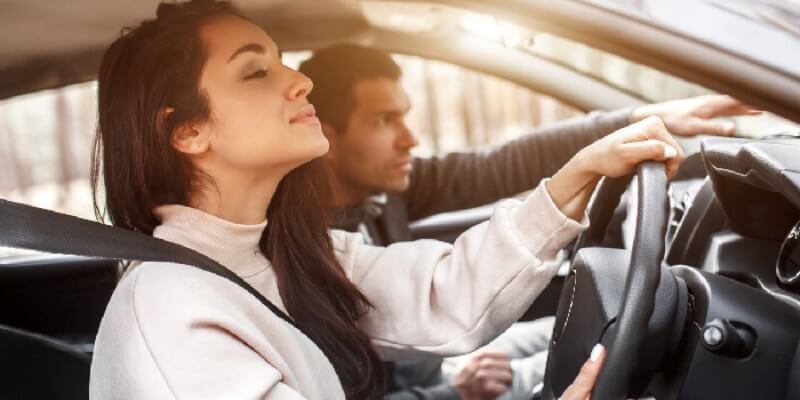 Girl and man in the car looking over the dashboard